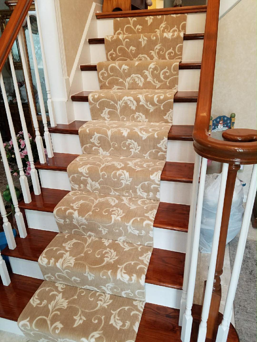 Beige scroll pattern carpet runner on stairs